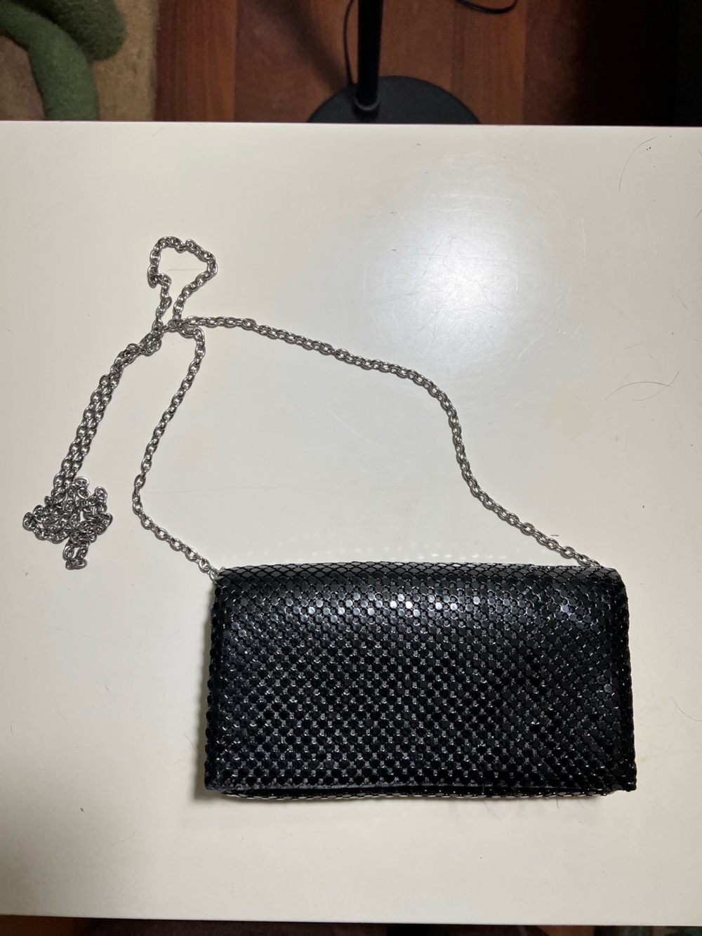 Black sequined clutch bag that converts to a shoulder bag. Silver chain strap.